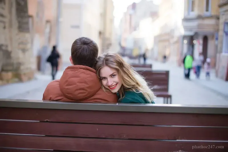 Cặp vợ chồng tuổi già ngồi bên cạnh nhau trên ghế dài trong vườn, biểu tượng tình yêu bền lâu