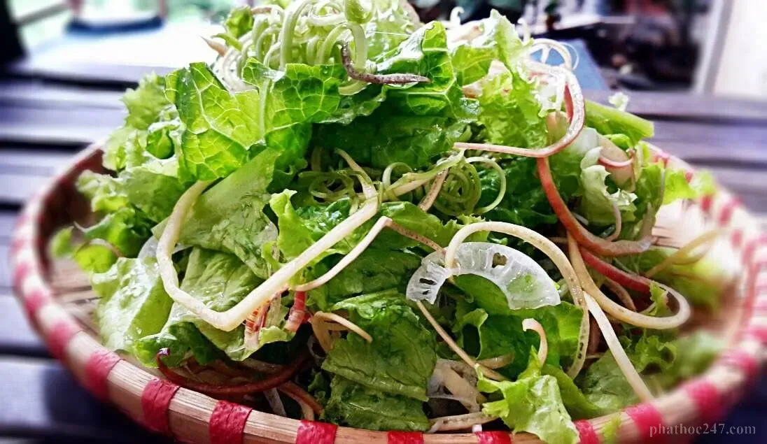 Rau sống được rửa sạch kỹ lưỡng dưới vòi nước trong bếp nhà được chiếu sáng tự nhiên