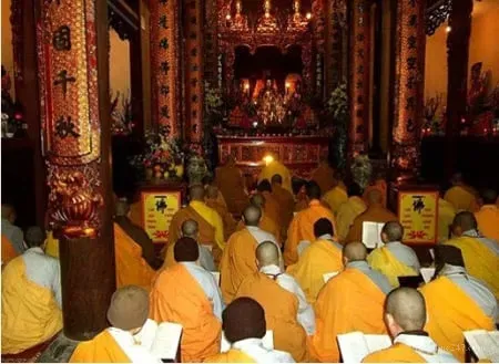 Vị tu sĩ tụng kinh Phật pháp trong chùa chiều tối với nến sáng tỏ mỏ